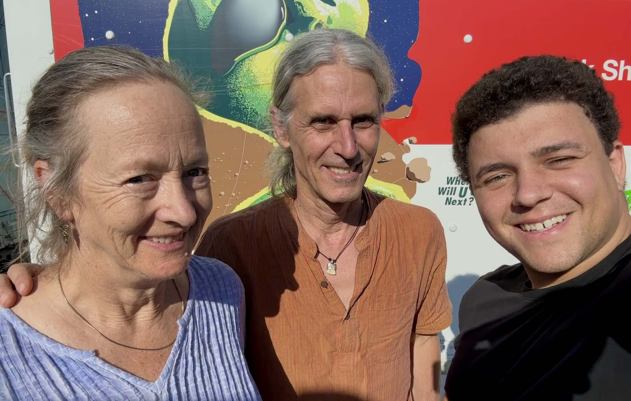 Former owners of Reflective Jewelry Helen Chantler and Marc Choyt pose with current owner Kyle Abraham Bi in front of an alien-themed New Mexico U-Haul during their 2023 trip to Milwaukee Irish Fest.
